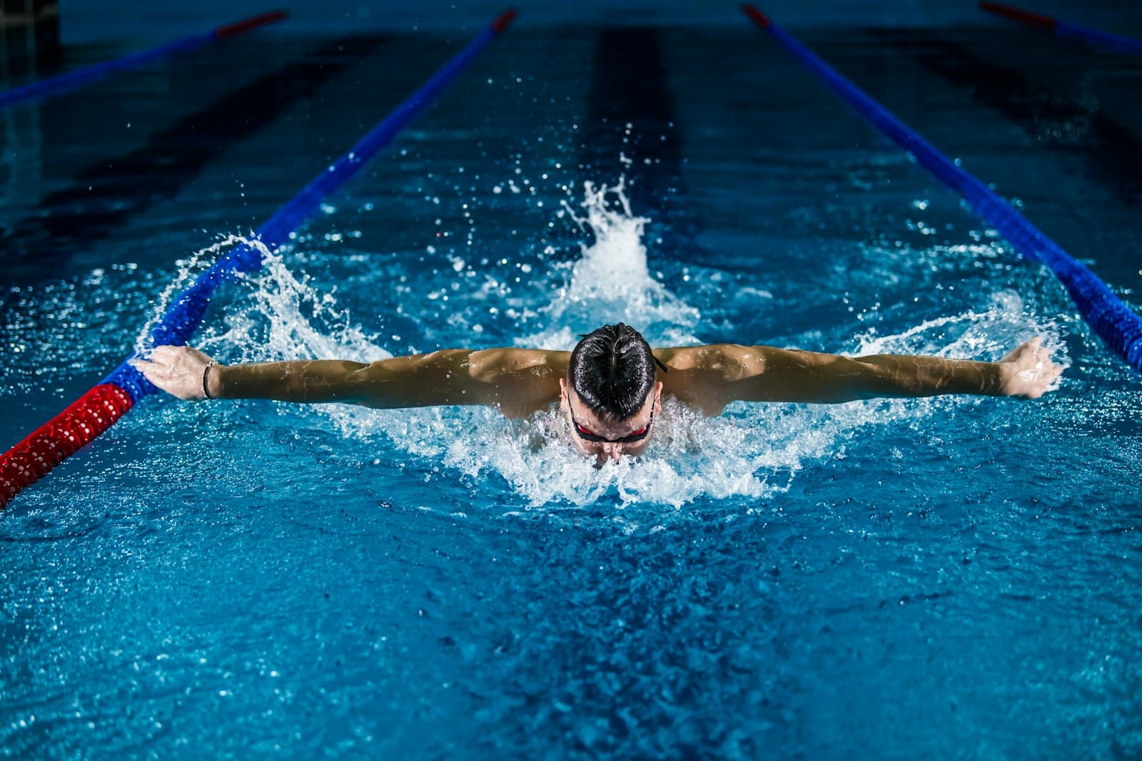 Competitive swimmer performing butterfly stroke in pool